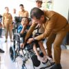 Ket. Foto: Bupati Kupang, Yosef Lede, SH saat Menyerahkan Bantuan Kursi Roda dari Kemensos Efata Kupang kepada Bocah Disabilitas.